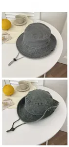 Detail of grey washed canvas sun hat featuring metal vents and adjustable chin strap