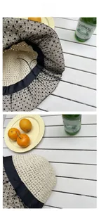 Detail view of beige woven straw hat with black polka dot mesh and satin ribbon trim
