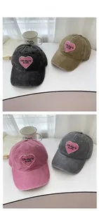 Detail showing vintage washed cotton baseball caps with pink heart embroidery in four colors