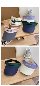 Close-up of Greenich embroidery on multi-color canvas sun visors in various soft shades