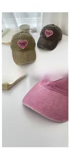Detail of pink heart embroidery patch on vintage washed cotton baseball cap texture