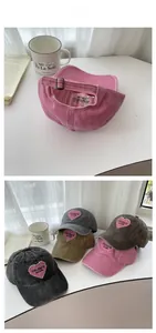 Detail view of heart embroidery on washed cotton baseball caps with metal buckle adjustment