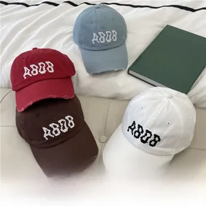 Detailed embroidery of ABDB logo on distressed cotton baseball caps in various colors