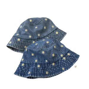 Retro denim bucket hats for women with white daisy embroidery in light and medium blue wash