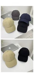 Close-up of quick-dry baseball caps in khaki, black, navy, and grey on a white desk