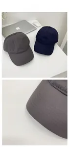 Detail of the stitching on curved brim of quick-dry baseball caps in grey and navy