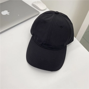 Minimalist black quick-dry baseball cap on office desk with laptop for outdoor sports