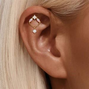Detail of 925 silver helix piercing with white opal stones and a dangling chain diamond