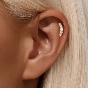 Macro shot of curved 925 silver ear stud with marquise opal and round zirconia gems