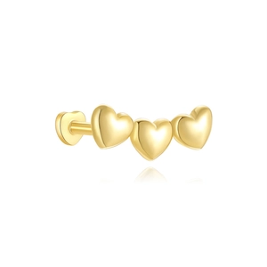 Detailed macro view of triple heart gold cartilage stud with flat back screw design