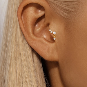 Detailed view of gold s925 silver lotus ear stud with zircon stones on female ear cartilage