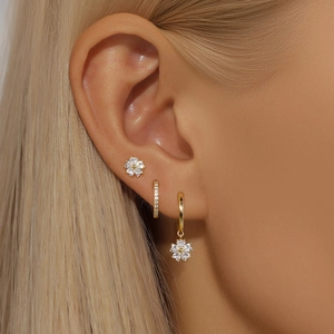 Gros plan d'un ensemble de boucles d'oreilles dorées avec fleurs en zircone