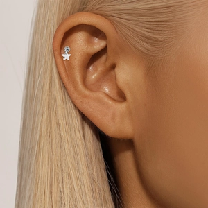 Close-up of a s925 silver star-shaped cartilage stud earring on a human ear