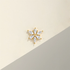 Macro view of snowflake silver stud earring with gold plating and clear cubic zirconia