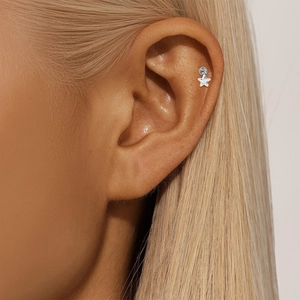 Close-up of S925 sterling silver star helix piercing earring on female ear