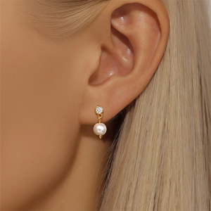 Detail of s925 silver clover earring with zircon and pearl on a model's ear