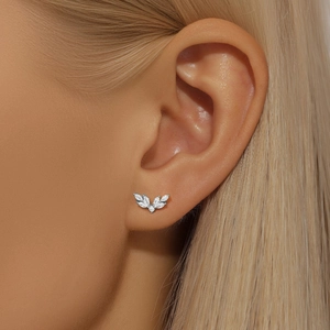 Close-up of S925 sterling silver leaf earring with cubic zirconia on female model ear