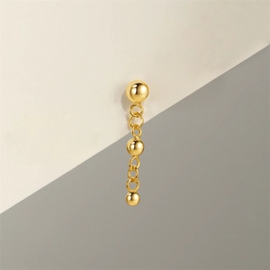 Close-up of S925 silver gold-plated drop earring with triple polished beads on bicolor background