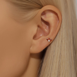 Close-up of a floral S925 silver stud earring with orange pear-cut zircons on an ear