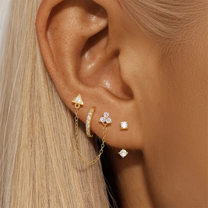 Primer plano de pendientes triangulares de plata S925 con borlas y brillantes en la oreja