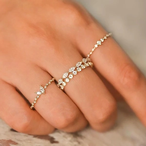 Elegant gold stacked rings with marquise cut diamonds shown on a female finger detail