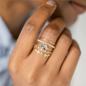 Detailed shot of stackable s925 silver rings with blue crystals and laurel leaf design