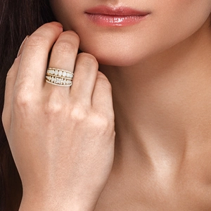 Close-up of stacked gold pavé rings with sparkling crystals on a model's finger