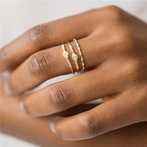 Macro detail of a 3-piece gold-plated S925 silver ring set with geometric zircons