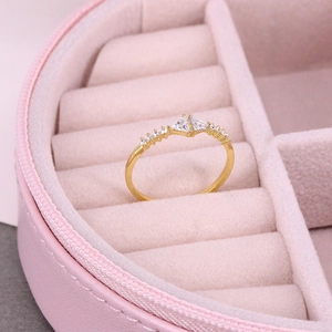 Detail view of gold band ring with twin triangular zircons in a pink velvet jewelry box