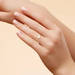Close-up of a s925 silver gold-plated ring with a square-cut diamond on a finger