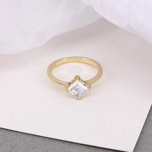 Macro shot of S925 sterling silver stamp on golden ring with emerald cut crystal