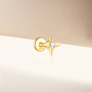 Detailed view of gold S925 sterling silver four-point star stud earring with clear zircon