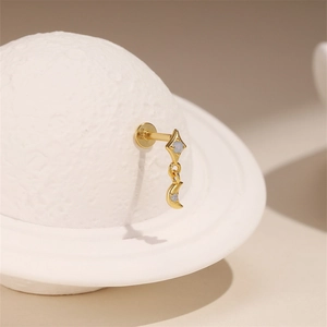 Macro detail of gold-plated silver celestial stud earring with opal inlay and moon motif