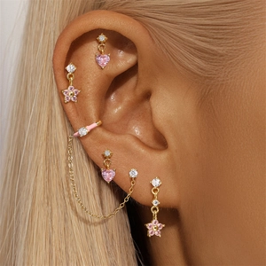 Close-up of golden stud earrings set featuring pink opal hearts and floral dangles