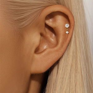 Close-up of gold s925 silver cartilage stud with double zircon stars on ear