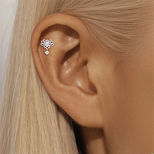 Macro shot of silver lotus hollow piercing stud with white crystal drop on a model