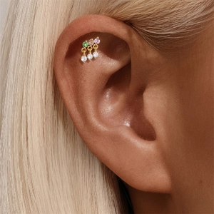 Close-up of gold helix stud featuring three colored gems and dangling zircon tassels