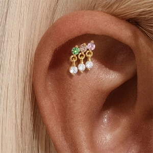 Detail of s925 silver stud earring with colorful stones and clear zircons on model ear
