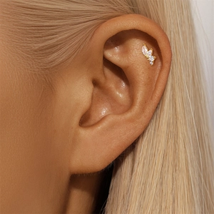 Close-up of gold stud earring with marquise and round white zircon leaf design on ear