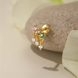 Macro shot of S925 sterling silver earring with pink and green stones on a stone base