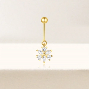 Detailopname van gouden navelpiercing met bloemhanger voorzien van zirkonia steentjes