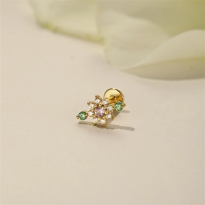 Detail of s925 silver flower stud earring with pink zircon and green gem accents