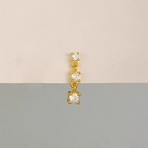 Close-up of gold-plated tassel earrings featuring three sparkling cubic zirconia stones