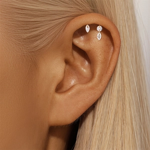 Close-up of marquise-shaped pink opal stud earrings with tassels on a female ear
