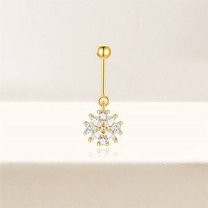 Detailopname van sneeuwvlok navelpiercing met zirkonia stenen en gouden afwerking