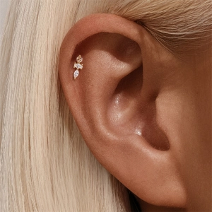 Close-up of pink and white zircon stud earring worn on the ear cartilage