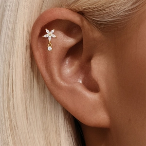 Macro shot of a gold flower cartilage stud featuring marquise-shaped pink opal stones