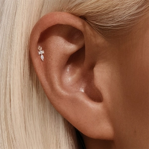 Macro shot of S925 silver helix piercing with champagne and white marquise zircons