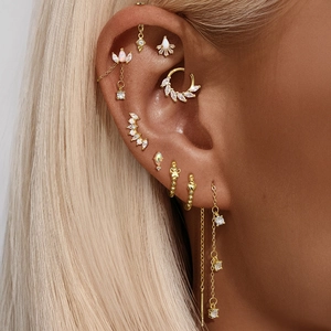 Detailed close-up of golden S925 silver stud earrings with opal and zircon on model
