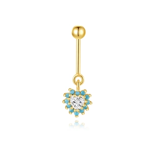 Gedetailleerde macro van gouden navelpiercing met hart-zirkonia en blauwe kralen
